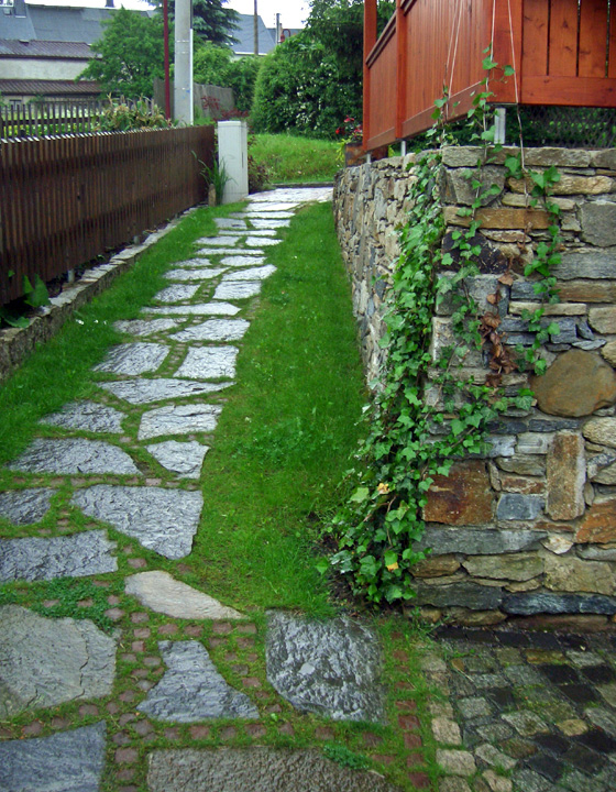 Referenzbild: 29 Natursteinmauerwerkensemble, Plattenbelag als Nebenweg mit einer Rasenfuge.