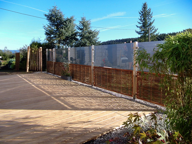 Referenzbild: 380 2 Eine Terrasse aus Edel - Kastanie ersetzt die Rasensplitterfläche.  Kombination aus Glas und Robinie schützt trotz Transparenz vor unliebsamen Blicken und Wind
