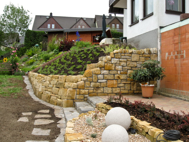 Referenzbild: 80 Eine Treppe aus Gneis und Platten führt von der Terrasse in den Garten. Aus Gneis wurde auch die Wegeführung und Mähkante hergestellt. 